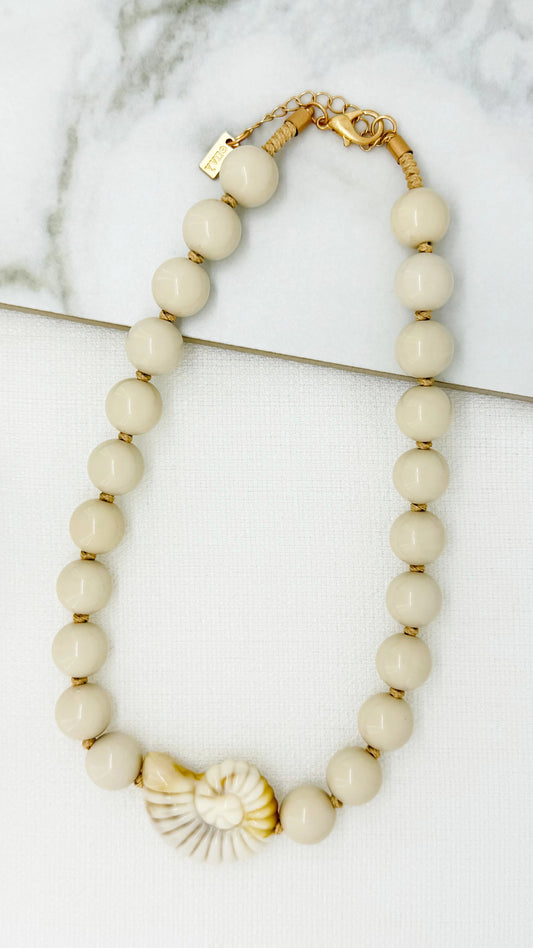 Short beige bead necklace with fossil pendant