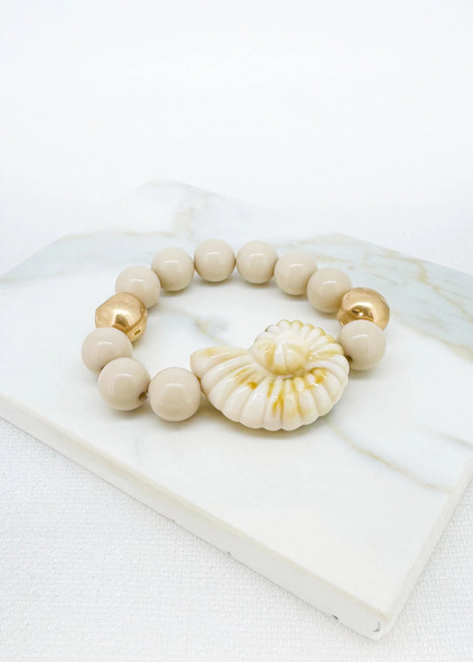 Beige and gold bead bracelet with fossil pendant