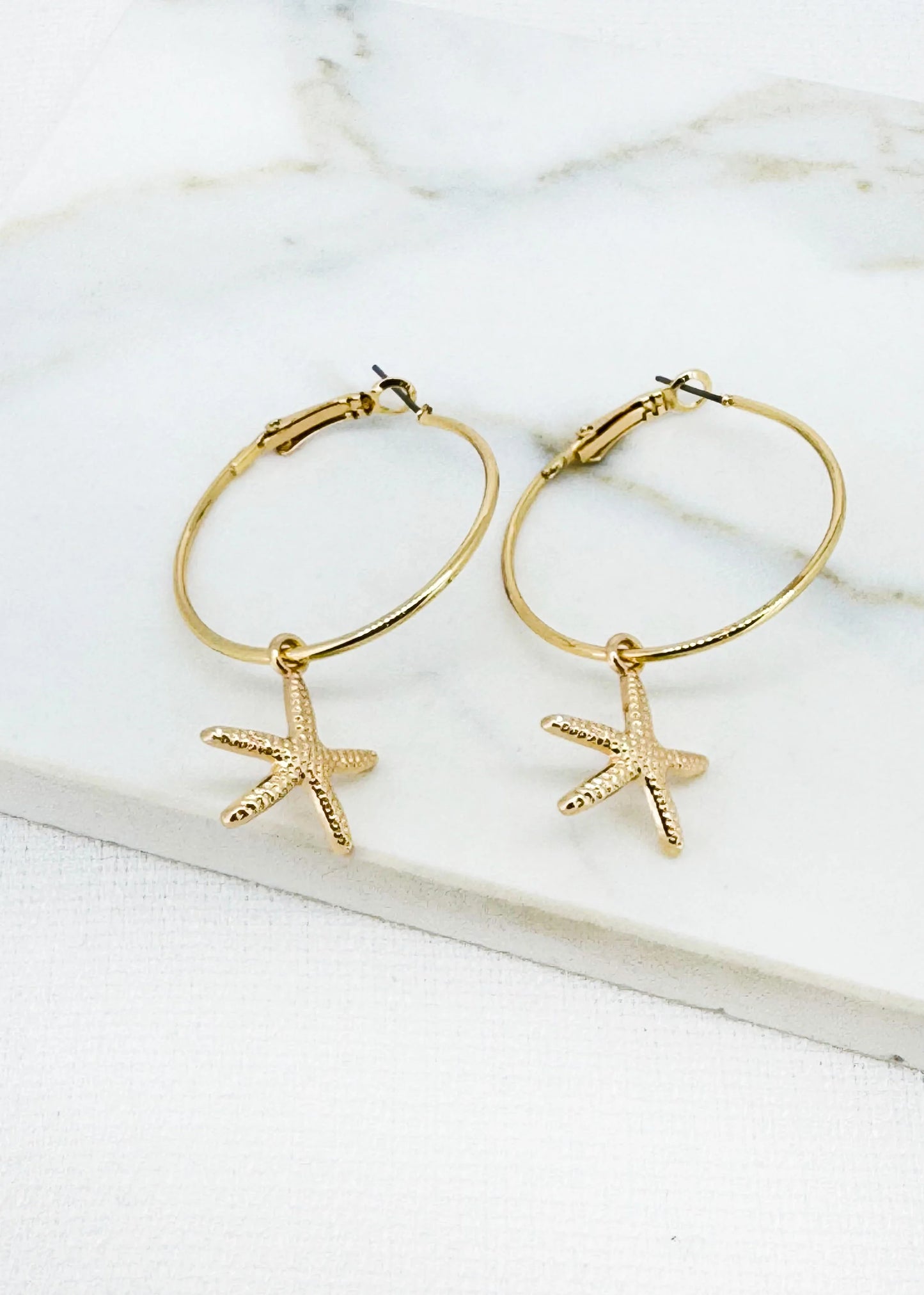 Gold hoop earring with starfish dropper